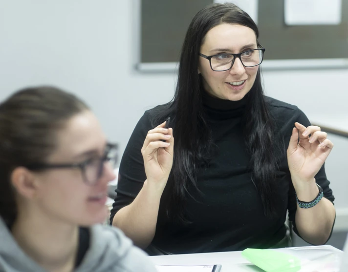 Student raises a point during an engaging discussion in a classroom setting. Student raises a point during an engaging discussion in a classroom setting.
